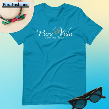 "Feel refreshed and rejuvenated in our serene aqua T-shirt, featuring the uplifting message 'Pura Vida' and a radiant sun graphic. Embrace the warmth of positivity with every wear. Find it now at PuraFashions.com."