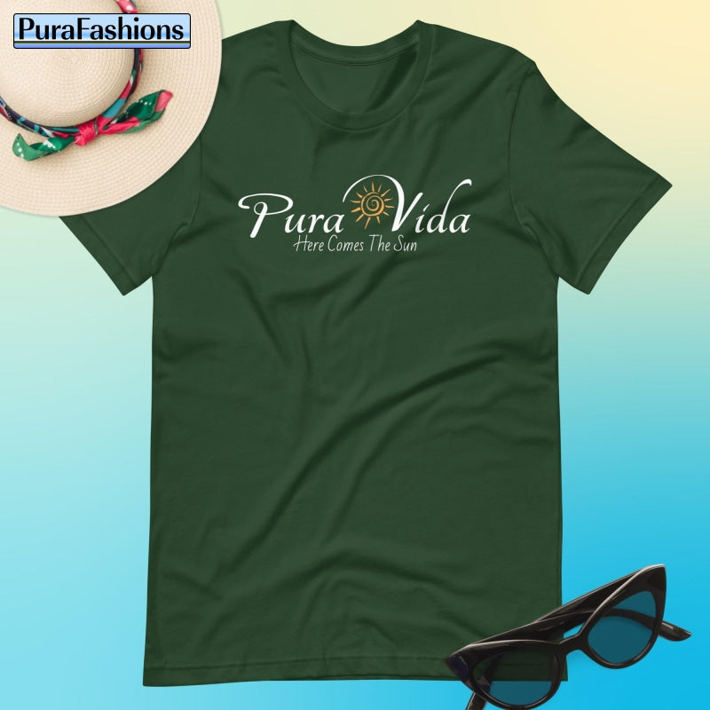 "Experience the essence of 'Pura Vida' in our lush forest green T-shirt, featuring a radiant sun graphic and the uplifting message 'Here Comes the Sun'. Discover serenity and style at PuraFashions.com."
