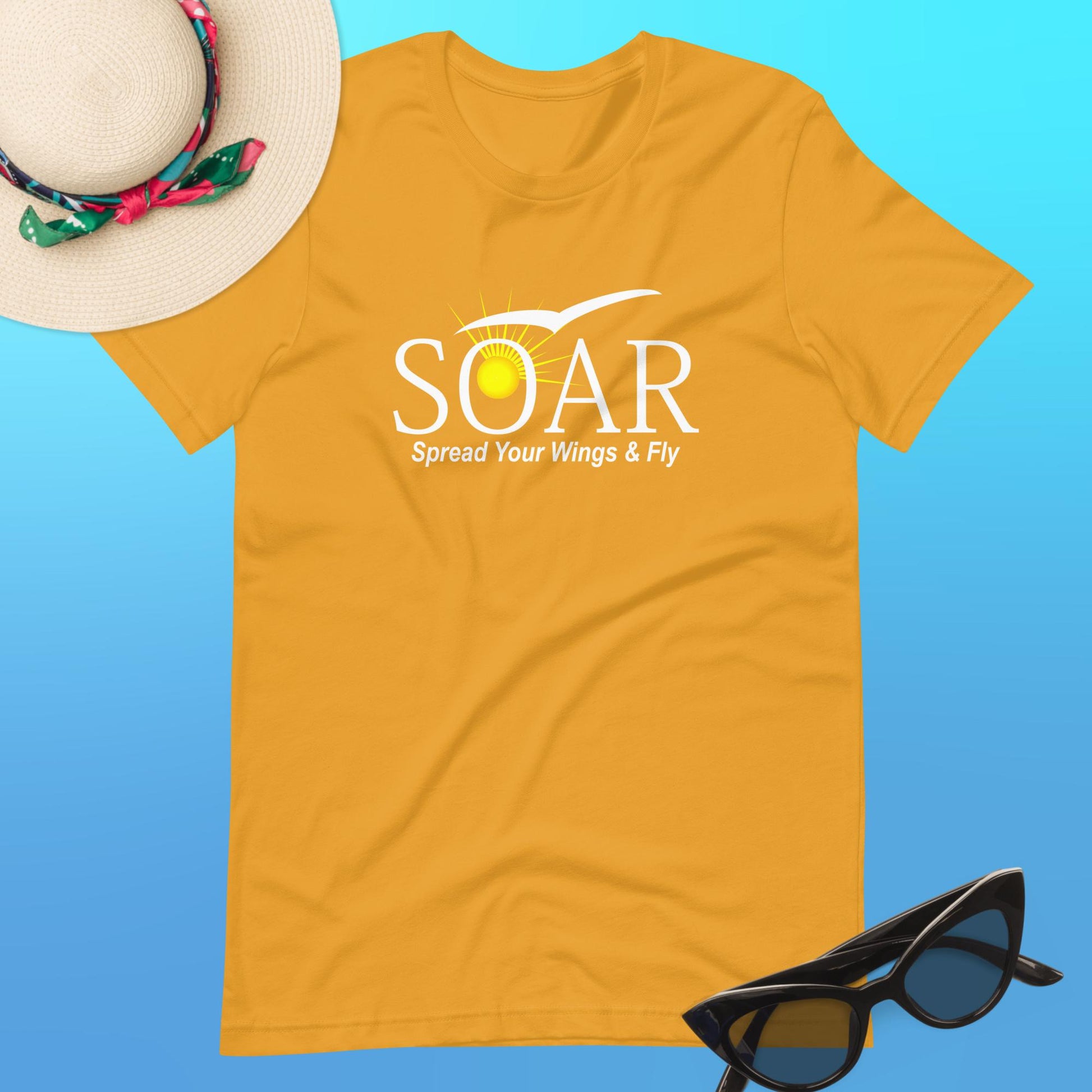 "Mustard Yellow T-Shirt featuring 'SOAR' Graphic: Sun and Seagull Design Encouraging Flight. 'Spread your wings & fly' - Available at PuraFashions.com. Flat-lay image displaying the front design."