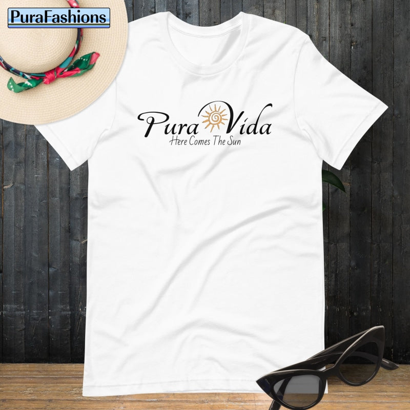 "Radiate pure positivity in our crisp white T-shirt, featuring the empowering message 'Pura Vida' and a vibrant sun graphic. Embrace the warmth of optimism with every wear. Discover it now at PuraFashions.com."
