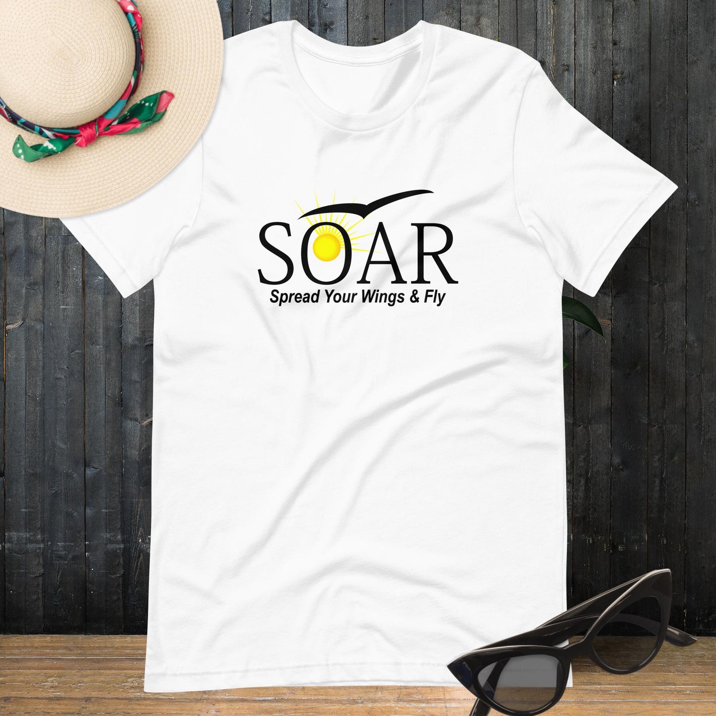 "White T-Shirt with 'SOAR' Graphic: Sun and Seagull Design, Motivating Flight. 'Spread your wings & fly' - Available at PuraFashions.com. Flat-lay image highlighting the front design."