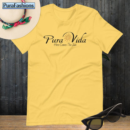 "Brighten up your day with our sunny yellow T-shirt, adorned with the uplifting message 'Pura Vida' and a radiant sun graphic. Embrace positivity and optimism with every wear. Find it now at PuraFashions.com."