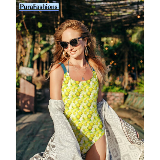"Poolside zest: A woman stands confidently in front of a sparkling swimming pool, showcasing a one-piece swimsuit from PuraFashions.com adorned with a lively lemon pattern against a crisp white background, embodying summertime freshness and vibrant style."