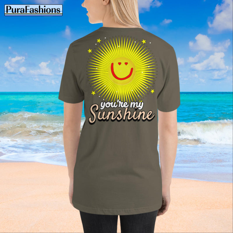 A woman wearing an army green T-shirt with a large happy face sun, stars, and the text "You're My Sunshine" on the back. The front features a small happy face sun and stars. Back view shown. Available at PuraFashions.com.