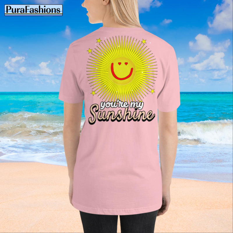 "Back view of a woman wearing an pink T-shirt with a large happy face sun and a few stars, along with the text 'You're My Sunshine'. The T-shirt has a small happy face sun and stars on the front as well. Available at PuraFashions.com."