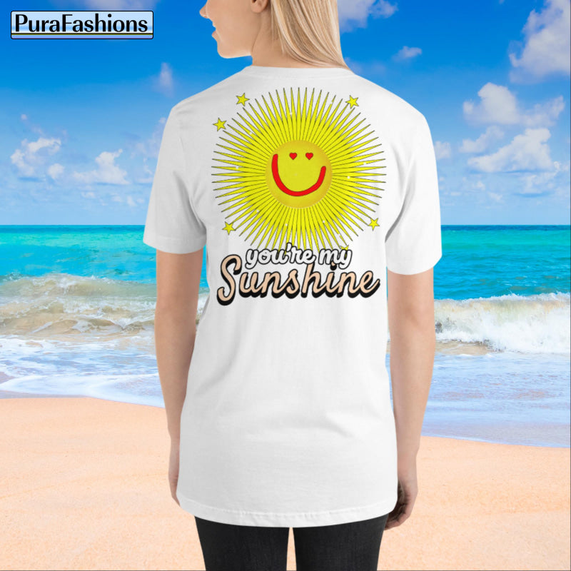 "Back view of a woman wearing an white T-shirt with a large happy face sun and a few stars, along with the text 'You're My Sunshine'. The T-shirt has a small happy face sun and stars on the front as well. Available at PuraFashions.com."