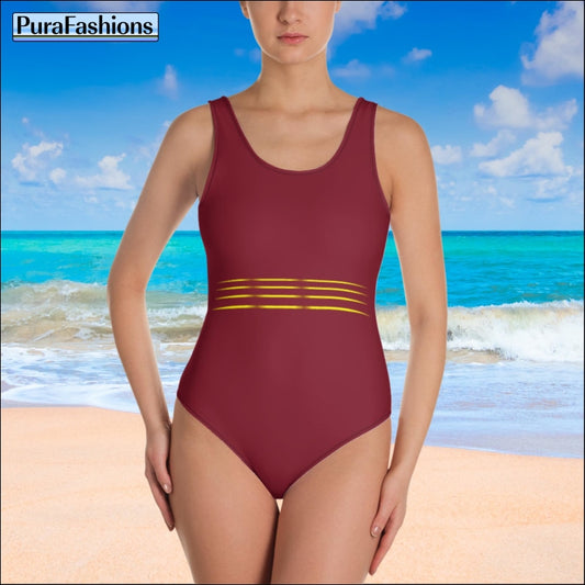 "Amidst the sunny beach backdrop, a woman shines in a burgundy one-piece swimsuit featuring a captivating multiline waist accent from PuraFashions.com."