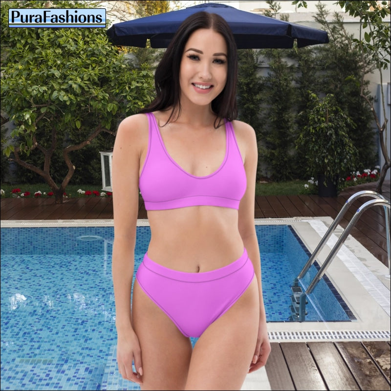 "Poolside chic: A woman stands confidently in front of a glistening swimming pool, showcasing a stylish pink high waist bikini from PuraFashions.com, radiating confidence and sophistication with every sun-kissed pose."