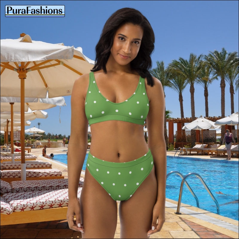 "Poolside charm: A woman stands confidently by the swimming pool, donning a stylish high waist bikini from PuraFashions.com adorned with white polka dots on a vibrant green background, exuding playful elegance and timeless charm against the tranquil blue waters."